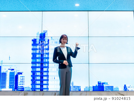 巨大ディスプレイの前に立つビジネスパーソン　ガッツポーズ 91024815