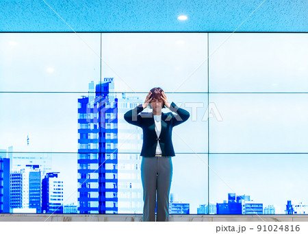 巨大ディスプレイの前に立つビジネスパーソン　頭を抱える 91024816