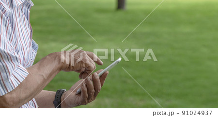 公園でスマホを使っている年配の男性 公園でスマホを使っている年配の男性 91024937