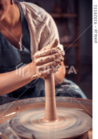 Potter master woman creates a new pottery from clay on a potter's wheel. Handicraft. Close-up. 91026531