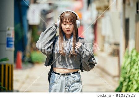ヘッドフォンで音楽を聴くZ世代の女性 91027825