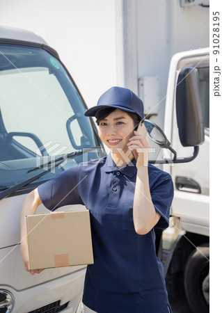 物流・運送業界　スマートフォンで連絡をする女性 91028195
