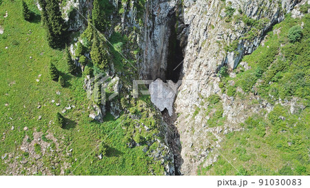Top view of steep mountain cliffs and an ice cave. Top view of steep mountain cliffs and an ice cave. 91030083