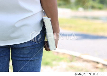 The back of a woman holding a book The back of a woman holding a book 91031052