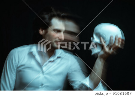 portrait of a psychopathic man with mental disorders with a human skull in hand 91031607