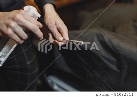 Barbershop. Close-up of barber holds razor for shaving his beard 91032511