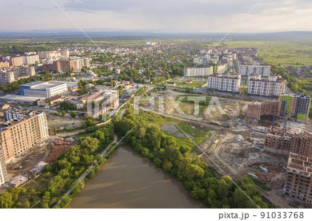 Top view of urban developing city landscape with tall apartment buildings and suburb houses. Drone aerial photography. 91033768