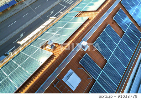 Top view of blue solar photo voltaic panels system on apartment building roof top. Renewable ecological green energy production concept. Top view of blue solar photo voltaic panels system on apartment building roof top. Renewable ecological green energy production concept. 91033779