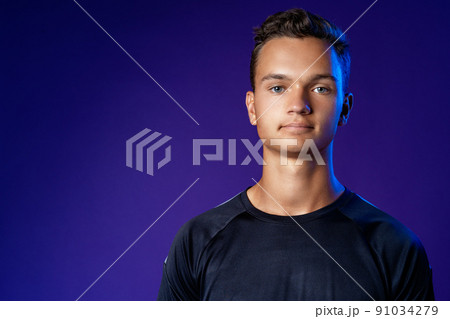 Portrait of a casual caucasian man against dark purple background Portrait of a casual caucasian man against dark purple background 91034279
