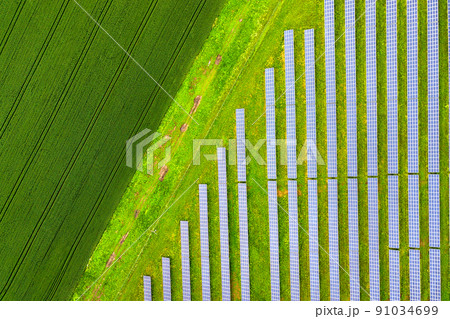 Aerial view of solar power plant on green field. Electric panels for producing clean ecologic energy. 91034699