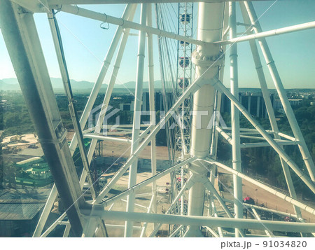 Ferris wheel. white metal beams. a huge reliable design, a carousel in the park for children. metal rods painted white 91034820