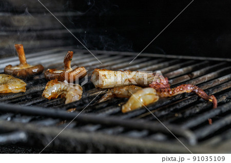Process of grilling seafood on a barbecue grill over hot coal. Seafood recipes Process of grilling seafood on a barbecue grill over hot coal. Seafood recipes 91035109