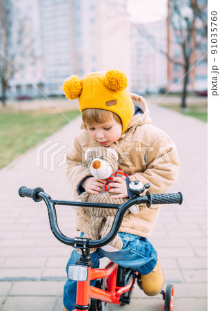 A small child learns to ride a bike for the first time in the city in spring 91035760