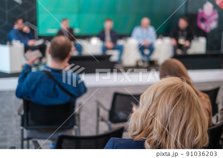 Anonymous people listening to speakers on stage during forum Anonymous people listening to speakers on stage during forum 91036203