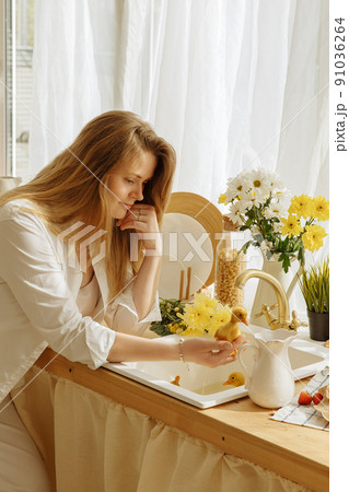 Women look at little ducklings in the sink in the kitchen. Women look at little ducklings in the sink in the kitchen. 91036264