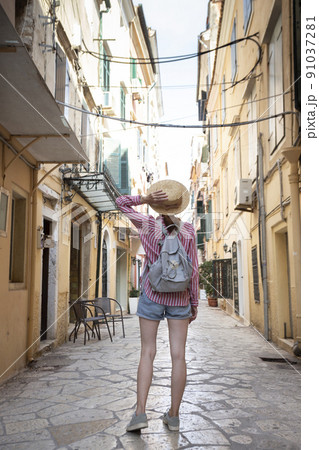girl in a hat walks on the street of the ancient Greek city girl in a hat walks on the street of the ancient Greek city 91037281