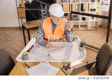 Positiv bearded mature man wearing orange reflective vest, and construction hard hat. 91038346