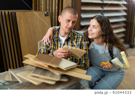 Man and woman chooses laminate flooring in store 91044333