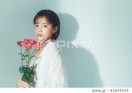 花を持つ若い女性 91044344
