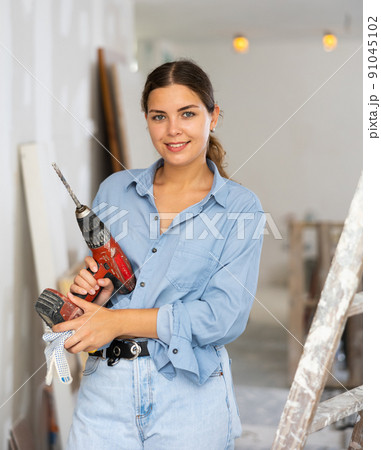 Portrait of a contented young woman with a screwdriver in hands Portrait of a contented young woman with a screwdriver in hands 91045102