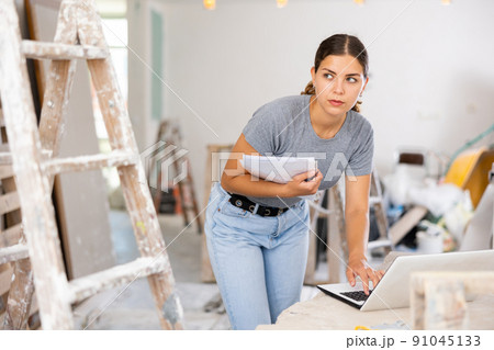 Woman designer using laptop in construction site Woman designer using laptop in construction site 91045133