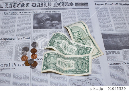 英字新聞に置かれた米国の1ドル紙幣と5ドル紙幣とコイン 英字新聞に置かれた米国の1ドル紙幣と5ドル紙幣とコイン 91045529