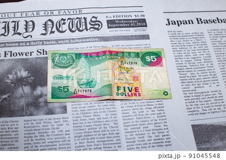 英字新聞に置かれたシンガポールドル 91045548