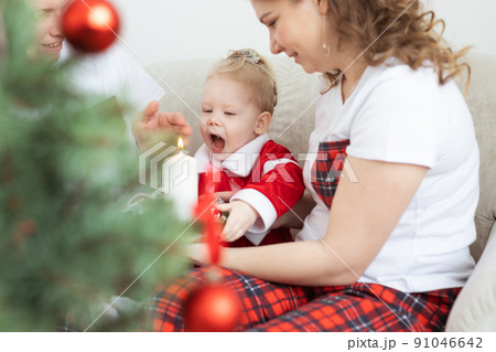 Baby child with hearing aid and cochlear implant having fun with parents in christmas room. Deaf , diversity and health concept Baby child with hearing aid and cochlear implant having fun with parents in christmas room. Deaf , diversity and health concept 91046642