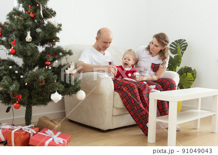 Baby child with hearing aid and cochlear implant having fun with parents in christmas room. Deaf , diversity and health and diversity Baby child with hearing aid and cochlear implant having fun with parents in christmas room. Deaf , diversity and health and diversity 91049043