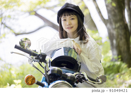 バイク女子イメージ　森の中でバイクにまたがる若い女性 91049421