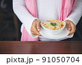hand woman suggesting exquisite restaurant appetizer Spinach with cheese in white bowl 91050704