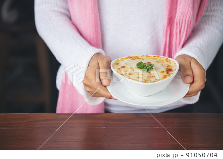 hand woman suggesting exquisite restaurant appetizer Spinach with cheese in white bowl hand woman suggesting exquisite restaurant appetizer Spinach with cheese in white bowl 91050704
