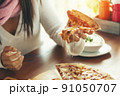 female models eating pizza on wood table blurred 91050707