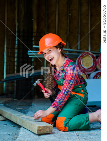 cheerful child laborer using building uniform and hammer tool, working day cheerful child laborer using building uniform and hammer tool, working day 91050765