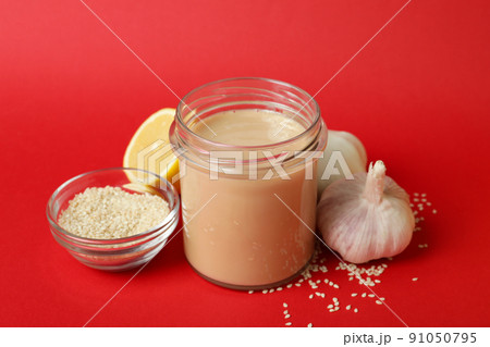 Concept of tasty food with tahini sauce on red background Concept of tasty food with tahini sauce on red background 91050795
