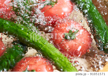 胡瓜とトマトを桶で洗う 胡瓜とトマトを桶で洗う 91051571