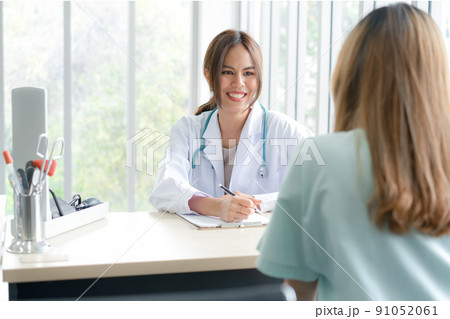 A female doctor talks to patients to treat their ailments and recommend ways to take care of themselves. A female doctor talks to patients to treat their ailments and recommend ways to take care of themselves. 91052061