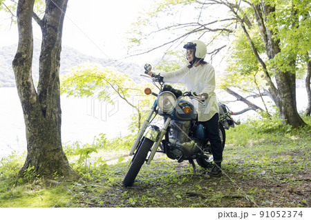湖畔でバイクに乗る若い女性　バイク女子 91052374