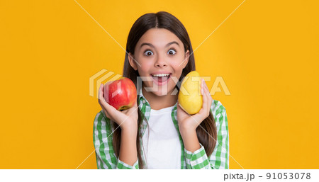 amazed kid with fresh apple and pear on yellow background 91053078