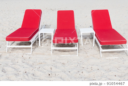Red deckchairs or sunloungers on sand beach in summer 91054467