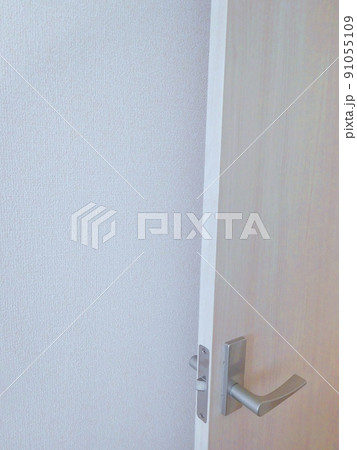 部屋の開け放したドアと白い壁紙 91055109