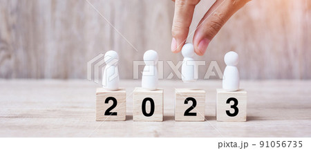 hand holding businessman over block building with 2023 text. leadership, business, team, teamwork and New Year Resolution concept hand holding businessman over block building with 2023 text. leadership, business, team, teamwork and New Year Resolution concept 91056735