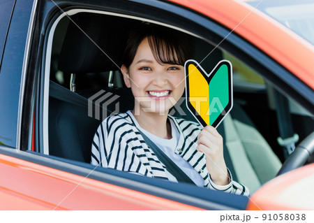 初心者マークを持った若い女性ドライバー 91058038