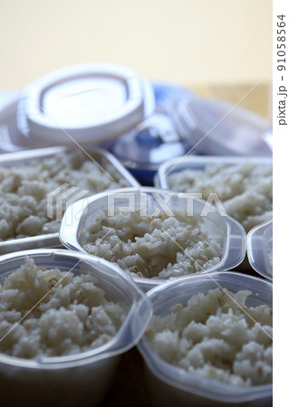 保存容器に小分けにしている炊き立ての押し麦入りご飯 保存容器に小分けにしている炊き立ての押し麦入りご飯 91058564
