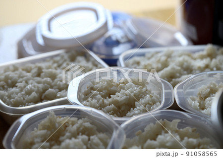保存容器に小分けにしている炊き立ての押し麦入りご飯 保存容器に小分けにしている炊き立ての押し麦入りご飯 91058565