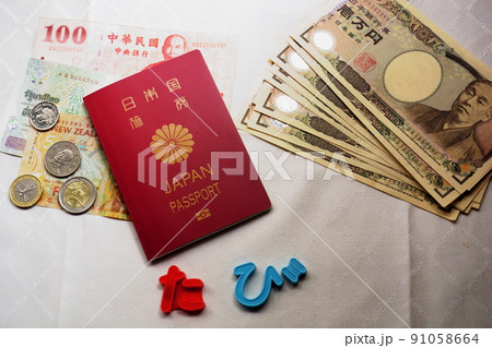 白を背景に置かれたパスポート、外貨、一万円札 91058664