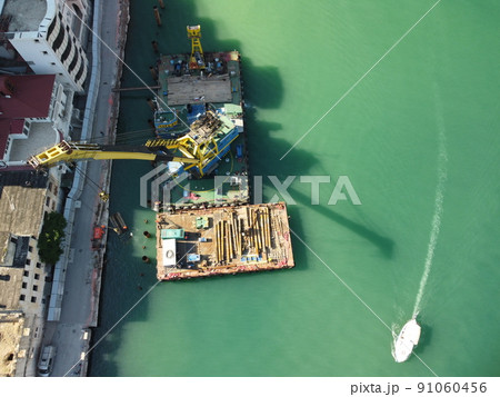 Floating crane dredging barges working on the construction of a marina. Aerial top view 91060456