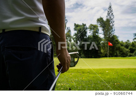 man white shirt blue pants In his hand, the putter prepares for the next golf shot. man white shirt blue pants In his hand, the putter prepares for the next golf shot. 91060744