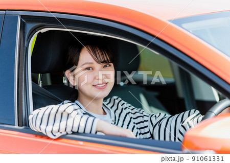 笑顔で車の運転をする若い女性 笑顔で車の運転をする若い女性 91061331
