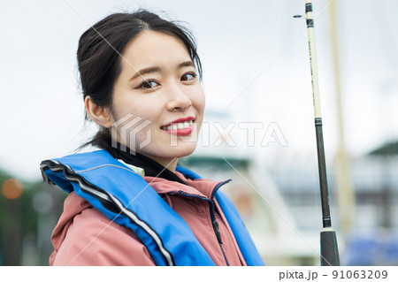 魚釣りをするかわいい女性 魚釣りをするかわいい女性 91063209